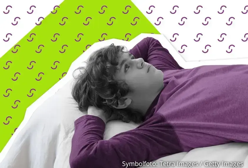 Junge liegt nachdenklich auf seinem Bett und hat die Arme unterm Kopf verschr&auml;nkt