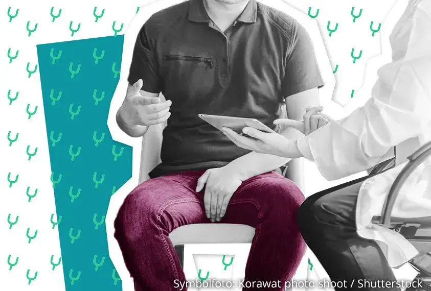 Mann spricht mit Arzt und h&auml;lt eine Hand vor seinen Schritt