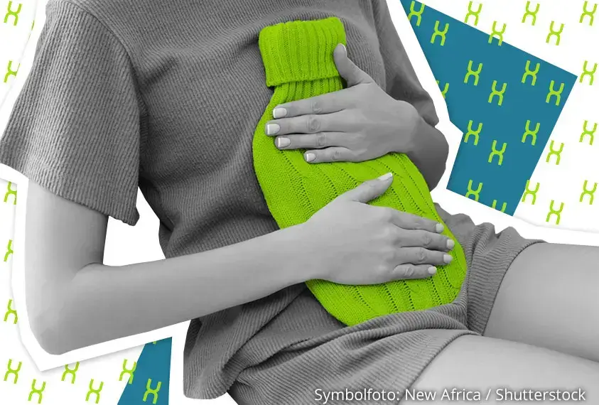 Ein M&auml;dchen h&auml;lt sich eine W&auml;rmflasche auf den Bauch