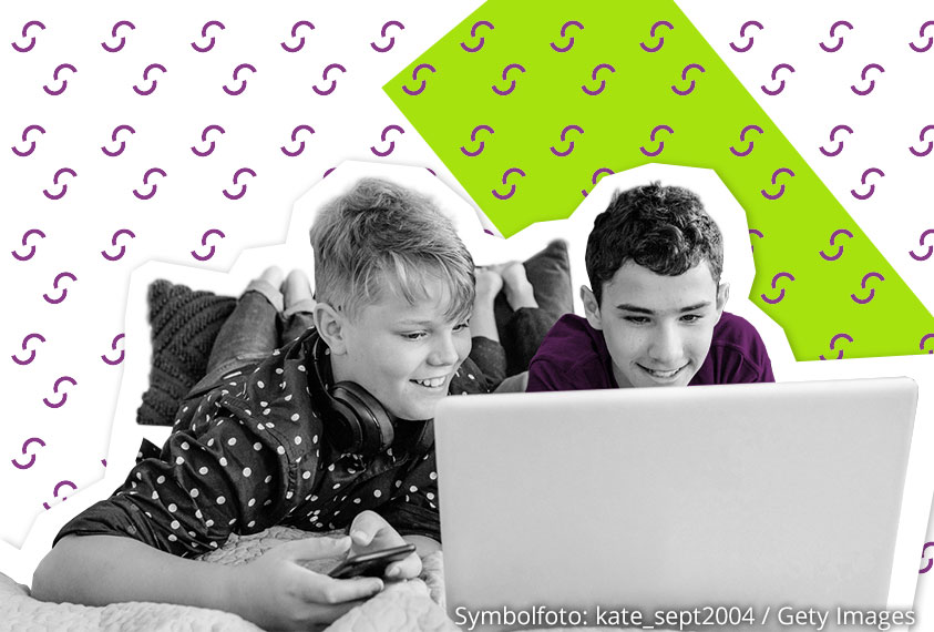 Zwei Jungs vor einem Laptop, die sich etwas im Internet ansehen 